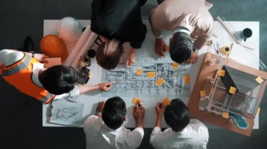 Becerikli mühendis ekibinin ev inşaatından bahsedişinin en alt görüntüsü. Mimar ya da tasarımcı grubunun planlar hakkında beyin fırtınası yapmak için tartışan ve yazan hava görüşü. Hizalama.