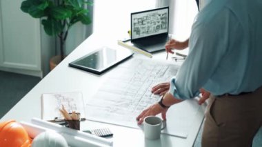 Proje planının dizüstü bilgisayarında ev inşaatı ve ekipmanlarıyla toplantı masasında oturup plan yazarken yöneticilerin konuşmalarının ve ev inşaatı hakkında tartışmalarının en üst görüntüsü. Hizalama.