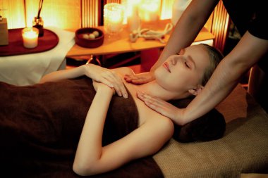 Beyaz kadın müşteri stres önleyici spa masajının keyfini çıkarıyor ve lüks otel ya da otelde sıcak mum ışığında güzellik teniyle eğleniyor. Sessiz.