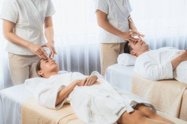 Kafkasyalı çift stres önleyici kafa masajının keyfini çıkarıyor ve lüks otellerde ya da otel spa salonlarında gündüz kaplıcalarında yüz güzelliği eğlencelerini şımartıyor. Sessiz.