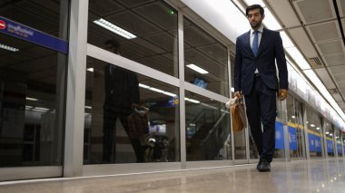 Elinde çanta ve kulaklıkla trende gezen zeki bir yönetici. Yakışıklı bir iş adamı evine, tren istasyonuna geri dönüyor. Uzman yatırımcı toplu taşımayı kullanıyor. Sevinçli..