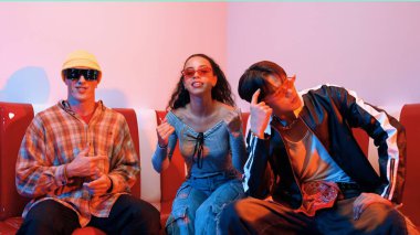 Mutlu kız kameraya bakıyor ve kanepede otururken pop müzik dinliyor. İspanyol kadın serbest stil dans ederken kameraya bakıyor neon ışıkta çeşitli arkadaşlarla dans ediyor. Mutluluk.