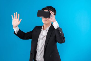 Asyalı işadamı, sanal gerçeklik mavi telif uzayı yenilik teknolojisini analiz eden gelecekçi metaevrendeki iş dünyası raporuna dokunarak ekranı titizlikle inceliyor. Entrika.