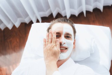 Kaplıca salonunun sakin atmosferi, insan müşterisi modern gün ışığında lüks yüz kremi masajıyla kendini yenileme zevkine kapılıyor. Yüz bakımı ve güzellik konsepti. Sessiz.