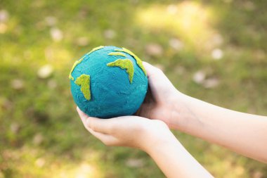 Dünya gezegenini ESG ilkesi ve çevre dostu enerjisiyle daha parlak bir gelecek için Dünya günü olarak el ele tutuşan genç çocuklar. Döngü