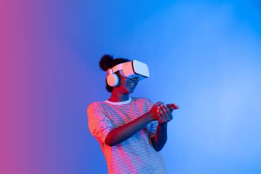 VR kullanan Afrikalı bir oyuncuyu avlamak, meta-evrende silah ateşleme oyunu oynamak, mavi neon ışığını izole etmek, zafer hayvanı avlamak, fütüristik teknoloji hologramı sanal gerçekliği. Entrika.