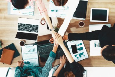İş adamları ve iş kadınları, takım çalışması, destek ve iş birliğini gösteren çok kültürlü ofis odasındaki grup toplantılarında el ele tutuşuyorlar. Çeşitli işyerleri ve şirket çalışanları konsepti. uds