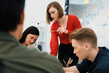 Toplantı odasında renkli yapışkan notlarla cam panonun önünde zihin haritası kullanarak pazarlama planıyla ilgili beyin fırtınası yapan mutlu çok ırklı iş grupları. Tertemiz..