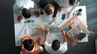 Yetenekli mühendis ekibinin proje planına bakarken konuştuğu en üst seviye görüntü. Birlikte çalışan ve mühendislik inşaatı için plan yapan bir grup akıllı iç mimar. Hizalama.