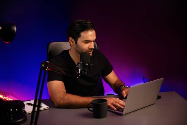 Yayıncı, fanclub dinleyicisiyle mikrofon kullanarak konuşuyor. Mor neon ışıklı modern stüdyoda yaratıcı olumlu düşünce konseptiyle canlı yayında finansal sorunları tartışıyor. Tahmin et..