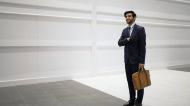 Akıllı yönetici beyaz arka planda dururken telefona bakıyor. Yakışıklı erkek lider e-posta kontrolü ya da güncellenmiş proje ve pazarlama stratejisi. Beyaz arka planda dururken. Sevinçli..