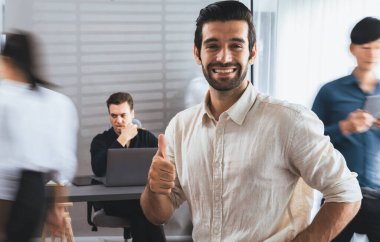 Ofiste çalışan iş arkadaşı ve iş adamlarının bulanık hareketli geçmişine sahip güler yüzlü iş adamı portresi. Ofis çalışanı takım çalışması ve pozitif iş yeri konsepti. Tedbirli