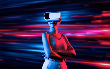 Zeki bir kadın, metaevreni birbirine bağlayan VR kulaklık takan neon ışıklarla çevrili duruyor. Gelecekteki siber uzay topluluğu teknolojisi. Zarif kadın kendinden emin bir şekilde çapraz kol pozu veriyor. Uzağa bak. Halüsinasyon.