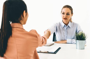 İş başvurusu ve iş anlaşması için ofis masasında toplanan iki genç iş kadını. İşe alım ve insan kaynakları kavramı. uds