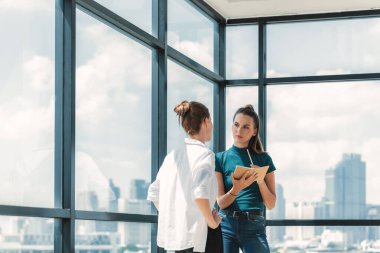 Portrait of young beautiful professional architect engineer team discuss about house design. Skilled businesswoman brainstorming and sharing marketing ideas surrounded by skyscraper. Tracery. clipart