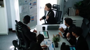 Akıllı yönetici projesinin üst görünümü beyaz tahtaya zihin haritası ve finansal grafik ile işaret ediyor ve çeşitli yatırımcılar hisse yatırım grafiğini dinleyip analiz ederken pazarlama fikrini açıklıyor. Müdürlük.