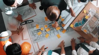 Proje planına bakarken mühendis ekibinin el sıkışması. Birlikte çalışan ve mühendislik inşaatı için plan yapan bir grup akıllı iç mimar. Hizalama.