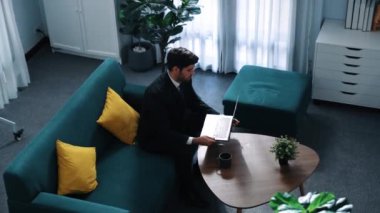 Kooperatif meslektaşı tableti tutarken ve performansını desteklerken, yetenekli proje yöneticisinin çalışma alanına gidip dizüstü bilgisayarda çalışmasının en üst görüntüsü. İş ekibi birlikte çalışıyor. Müdürlük.