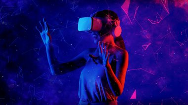 Heyecanlı gülümseyen Asyalı kadın VR metaevrenine bakıp mavi neon dijital evreni işaret ederek yıldızlı zodyak sanal uzay fantastik keşif nebulası meta-dünya. Halüsinasyon.
