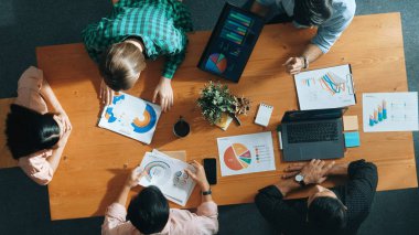 Proje yöneticisinin veri ve mali tabloyu analiz etmek için tablet kullanırken pazarlama ekibinin pazarlama kampanyası ya da toplantı odasında planlama stratejisi üzerinde birlikte çalışmasının en üst görüşü. Cemaat.