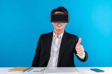 Asyalı işadamı meta ile bağlantı kurarak kameraya bakarak mavi telif uzayında gelecekteki yenilikçi teknoloji sanal gerçekliğini tanıtmaya çalışıyor. Entrika.