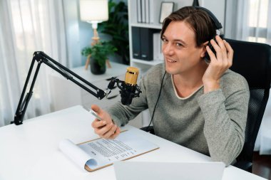 Sunucu kanalı, gülümseyen akıllı yayıncı kaydı, senaryosu ve akıllı telefonuyla sosyal medyada sohbet programı, kulaklık takarak modern ev stüdyosundaki video flamalarını kaydediyor. Bireysel.