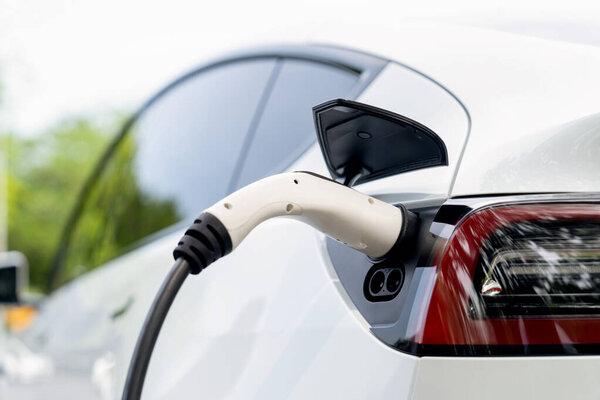 EV электрический автомобиль аккумулятор от зарядной станции EV в национальном парке или открытый лес живописный. Природная защита с экологически чистыми электромобилями путешествует в летнее время. Экзальт