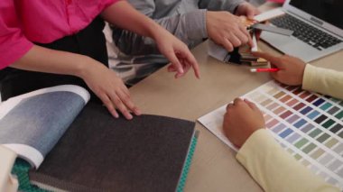Mimari ekipman kullanarak yavaş çekim ev tasarımcısı bir plan çizerken, iç mimari tasarımcı da müşterilerin talebine göre renk örneklerinden uygun renkler seçiyor. Değiştirilmiş