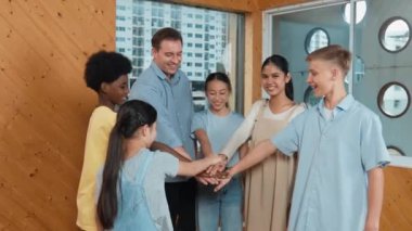 Kafkas öğretmeni ve çeşitli çocuklar sınıfta ayakta dururken başarılı projeyi kutlamak için el ele tutuşuyorlar. Aşkı, takım çalışmasını, güveni, birlikteliği ve birliği temsil et. Öğretim