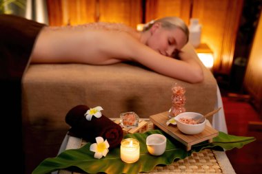 Lüks spa salonlarında sıcak mum ışığında cilt bakımı yaptıran kadın müşteri. Sağlık Spa vücut fırçasında tuz temizleme güzellik tedavisi. Sessiz.