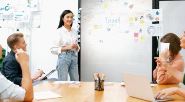 Genç ve güzel lider pazarlama stratejisini sunarken, uzman yatırımcı ve proje yöneticisi de yeni başlayan iş toplantısında iş performansını analiz etmeye çalışıyor. Çok ırklı bir grup. Tertemiz..