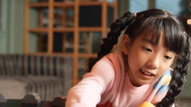 Arkadaşlarıyla oyun odasında oynaşan Asyalı tatlı bir kızın yakın çekimi. Çeşitli çocuklar hayal gücünü geliştirmek için araba modeli kullanıyorlar. Sevimli çocuklar robotik modelcilik oynamaktan hoşlanırlar. Eğitici bir oyun. Etkinlik.