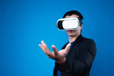 Meta evreni bağlayan VR cihazı takan, havada bir şeyler tutan iş adamlarının profili mavi arka plan fütüristik analitik iletişim teknolojisi sanal gerçeklik kopyalama uzayını izole etti. Entrika.