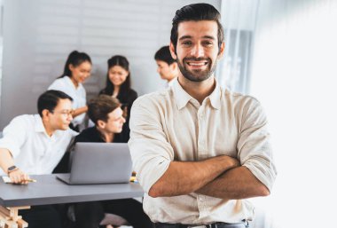 Ofiste çalışan iş arkadaşı ve iş adamlarının geçmişine sahip özgüven ve mutlu gülümseyen iş adamı portresi. Ofis çalışanı takım çalışması ve pozitif iş yeri konsepti. Tedbirli