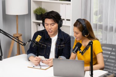 Gülümseyen radyo etkili sunucular, kulaklık takıp sosyal medyayı canlı yayında dinleyicilere telefon ve dizüstü bilgisayarla canlı yayınlıyorlar. İnfobahn.