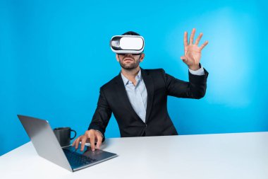 Bilgisayarla masada otururken ve VR gözlüğü takarken veri analizine bakan yetenekli bir iş adamı. Proje yöneticisi sanal gerçeklik sistemini kullanarak ya da metaevrende bağlantı kurarak çalışıyor. Sapma.