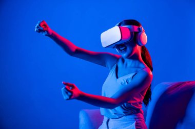 Akıllı Kadın, etrafı neon ışıklı kulaklıklarla çevrili bir kanepede oturuyor. Meta-evren, gelecekçi siber uzay teknolojisini birbirine bağlayan bir kulaklık takıyor. Zarif kadın meta-dünya araba yarışı oynuyor. Halüsinasyon.