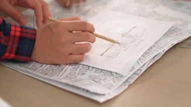 Mimari ekipmanlarla toplantı masasında ev tasarımı üzerine profesyonel mühendis ekibi tartışması ve modern ofiste bina planı dağılımı. Eline odaklan. - Yakın çekim. Tanımlama.