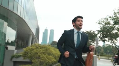 Keyifle dans eden yetenekli beyaz iş adamı soğukkanlılığını koru ve şehir merkezinde yürümeye devam et. Profesyonel menajer terfi ile ilgili iyi haberleri kutlamak için dans ediyor. Sevinçli..
