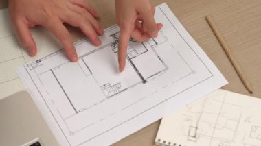 Akıllı mimar ve akıllı mühendisin dizüstü bilgisayarlı videosu mimarlık bürosundaki inşaat isabet planı hakkında tartışıyorlar. Eline odaklan. - Yakın çekim. Tanımlama.