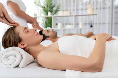 Kafkasyalı çift stres önleyici kafa masajının keyfini çıkarıyor ve lüks otellerde ya da otel spa salonlarında gündüz kaplıcalarında yüz güzelliği eğlencelerini şımartıyor. Sessiz.