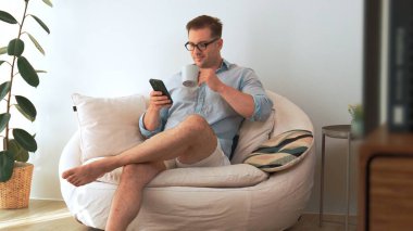 Orta yaşlı bir adam, iş için telefon arama verilerini kullanarak, çocukları iyi bir yetişkin ya da eğlence olsun diye odada kahve fincanıyla koltukta oturur. İşadamı teknolojiyi kolaylık için kullanır. Uyumsuzluk.