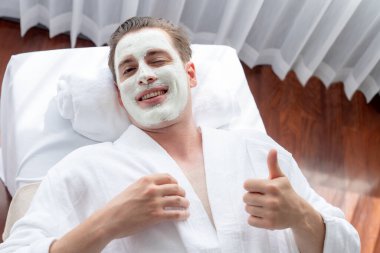 Kaplıca salonunun sakin atmosferi, insan müşterisi modern gün ışığında lüks yüz kremi masajıyla kendini yenileme zevkine kapılıyor. Yüz bakımı ve güzellik konsepti. Sessiz.