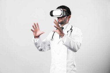 Zeki doktor, kameraya bakıyor ve beyaz arka planda duruyor. Sanal gerçeklik ya da metadünya giyerken tıbbi verileri elinde tutan ve kontrol eden beyaz bir doktor. Yenilik teknolojisi. Sapma.