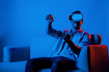 Mutlu adam, VR gözlük takıp neon ışıklı arka planda koltukta otururken araba sürüyor. Akıllı oyuncu, akıllı gözlük kullanarak araba sürerken spor yapıyor. Sapma.