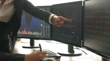 Menkul kıymetler borsası pazarlamasını inceleyen borsa yatırımcıları, zarar ve kazanç için mum bar fiyatlarını analiz eden monitörlere bakıyor. Filizlenen