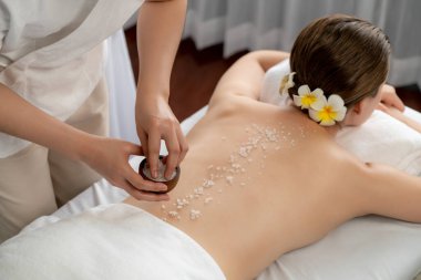 Lüks spa salonlarında sıcak mum ışığında cilt bakımı yaptıran kadın müşteri. Sağlık Spa vücut fırçasında tuz temizleme güzellik tedavisi. Sessiz.