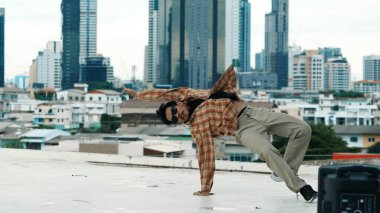 Çatıda çok kültürlü arkadaşlar varken profesyonel İspanyol break dansçısı B boy dansı. Genç modern dans grubu hip hop hareketi yapıyor. Tarz, moda, aksiyon. Açık hava sporu 2024 hiphop..