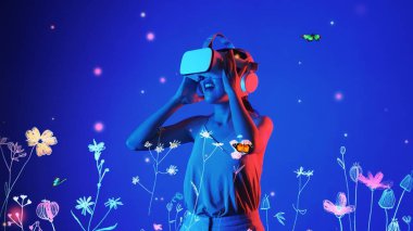 Güzel Asyalı kadın, VR ile metaevrensel etkileşimli sanal neon çiçekleri arasında kelebeklerle oynayan yeni neon çiçekleri mavi arka plan 3D grafik yüzen meta bahçe dünyası. Halüsinasyon.