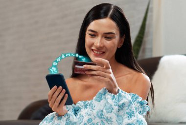 Beyaz tişörtlü, elinde kredi kartı olan şık bir müşteri çevrimiçi platform seçiyor. Açık e-ticaret uygulaması nakitsiz teknoloji alışveriş envanteri kullanırken akıllı tüketiciler dizüstü bilgisayar kullanıyor. Siber Nakit.